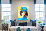 Vintage Barbie painting Fashion Editor by artist Judy Ragagli hanging above a creme sofa with blue pillows.